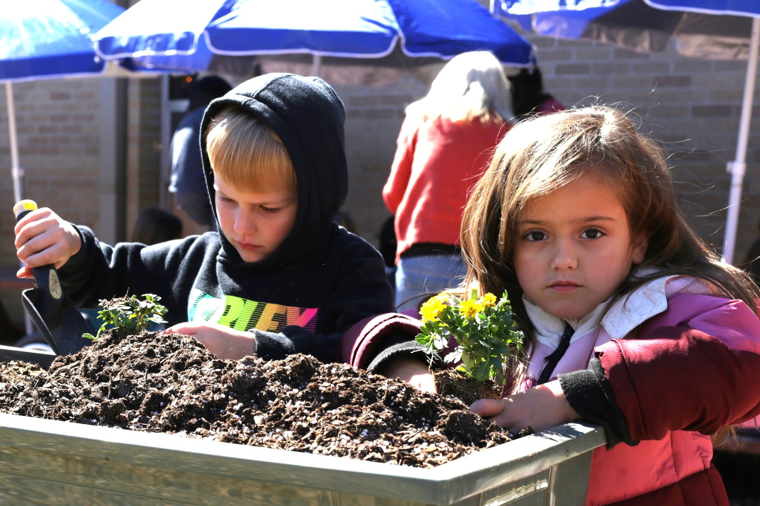 Levi Carver and Natalie Longoria, of Mrs. Richardson’s kindergarten class, commission the new garden by planting flowers.
